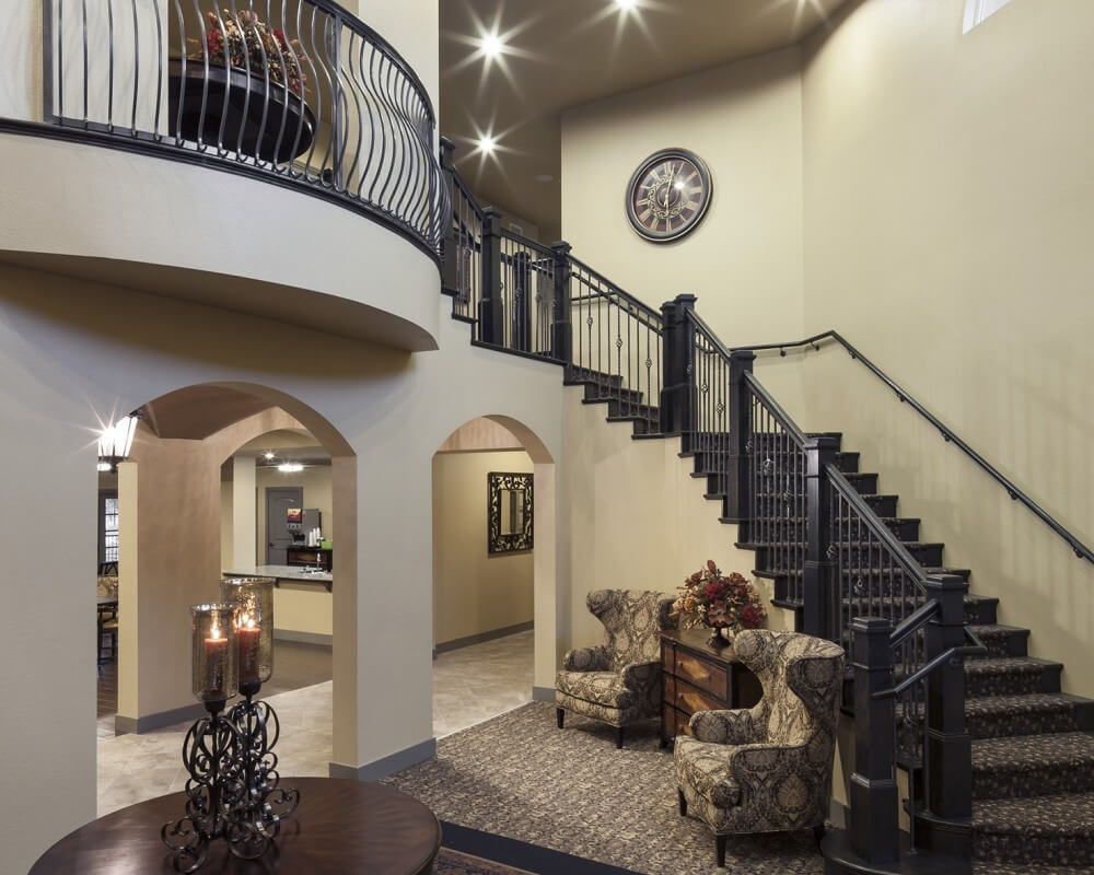 A modern living area featuring a grand staircase and elegant furnishings.