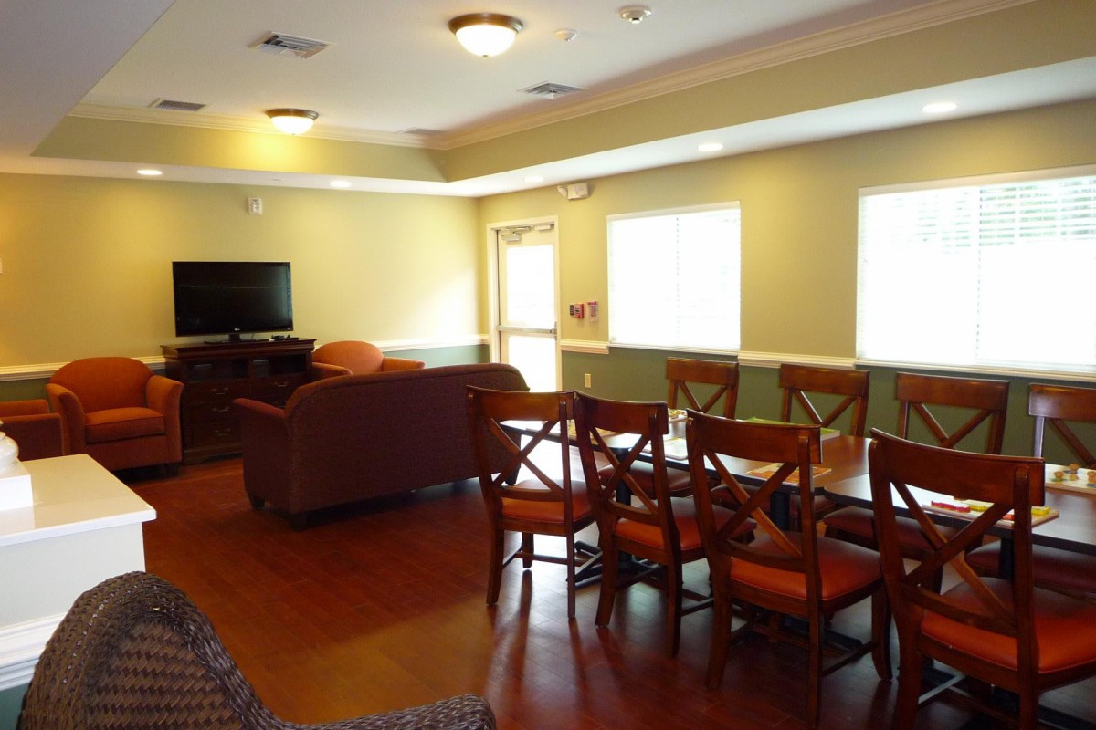 A cozy living and dining area with a sofa, chairs, and a television.