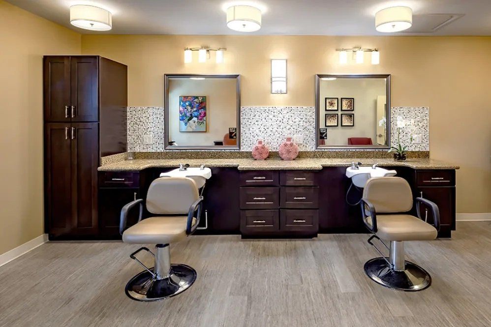A modern salon interior with stylish chairs and large mirrors.