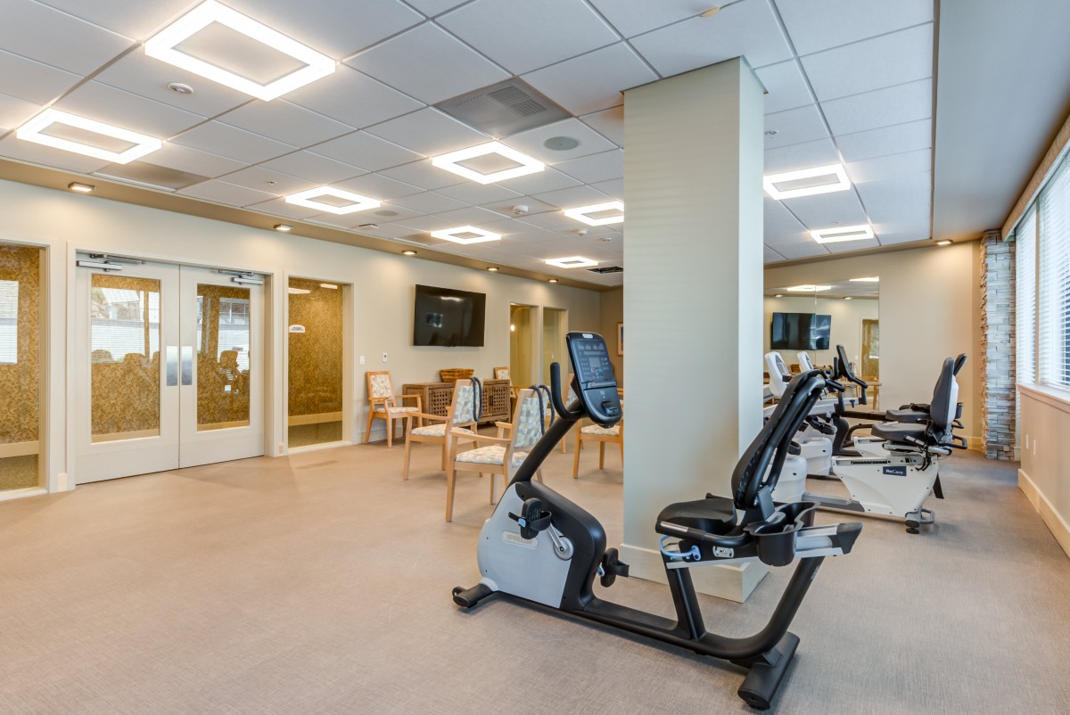 A modern fitness center featuring stationary bikes and seating area.