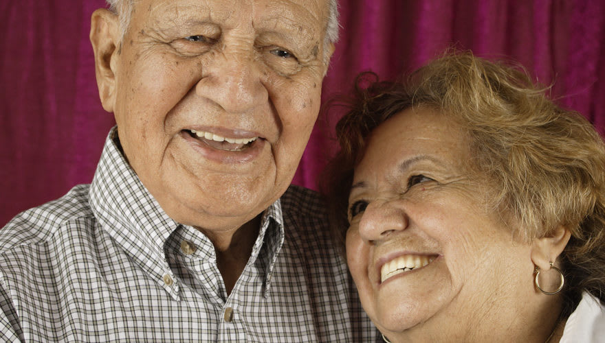 An elderly couple smiling and enjoying each other's company.