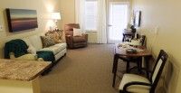 A cozy living room with a sofa, armchair, and a table.
