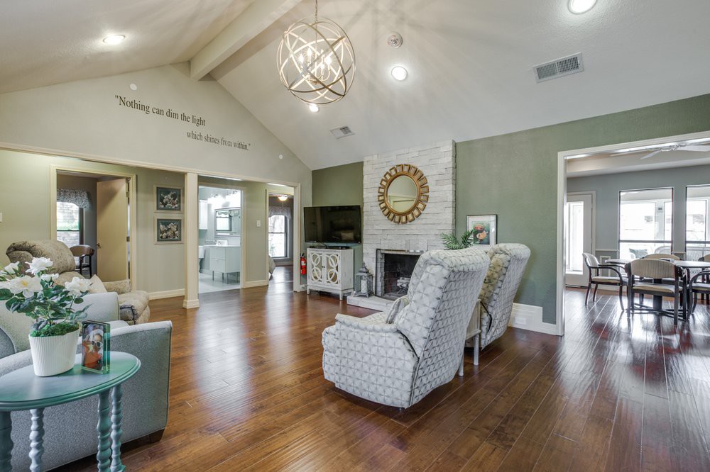 A spacious living room with high ceilings, featuring a fireplace and stylish furniture.