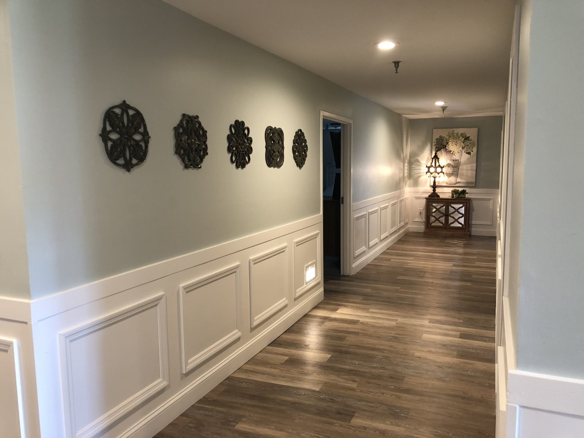 A beautifully decorated hallway with wall art and wooden flooring.
