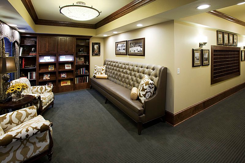 A cozy waiting area with a tufted bench, bookshelves, and soft lighting.