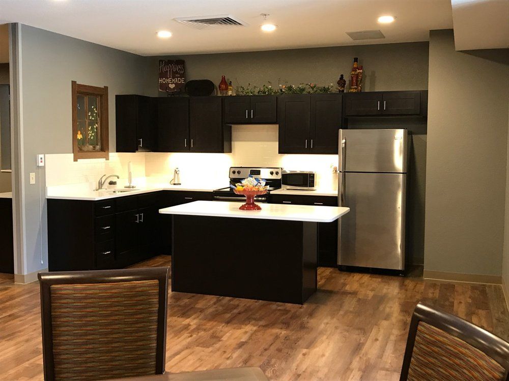 Modern kitchen with dark cabinets and stainless steel appliances.