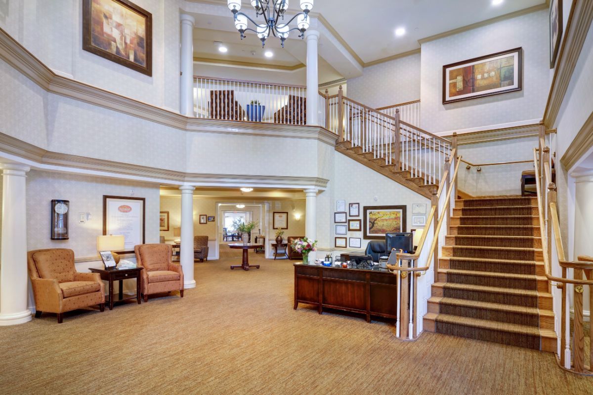 A spacious and elegantly decorated lobby with a grand staircase and chandelier.