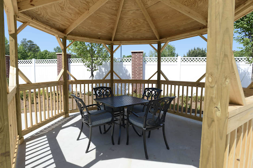 A cozy gazebo set up with a table and four chairs, perfect for enjoying outdoor gatherings.
