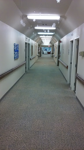 A clean and well-lit hospital hallway lined with doors.