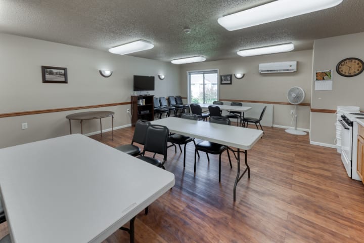 A well-lit meeting room with tables and chairs arranged for a conference.
