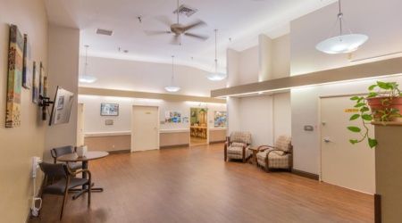 A spacious waiting room with comfortable seating and ceiling fans.