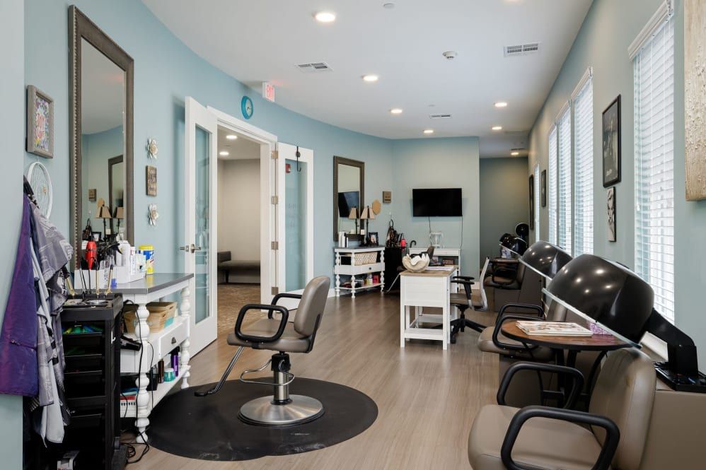 A modern and clean salon interior featuring chairs, mirrors, and a waiting area.