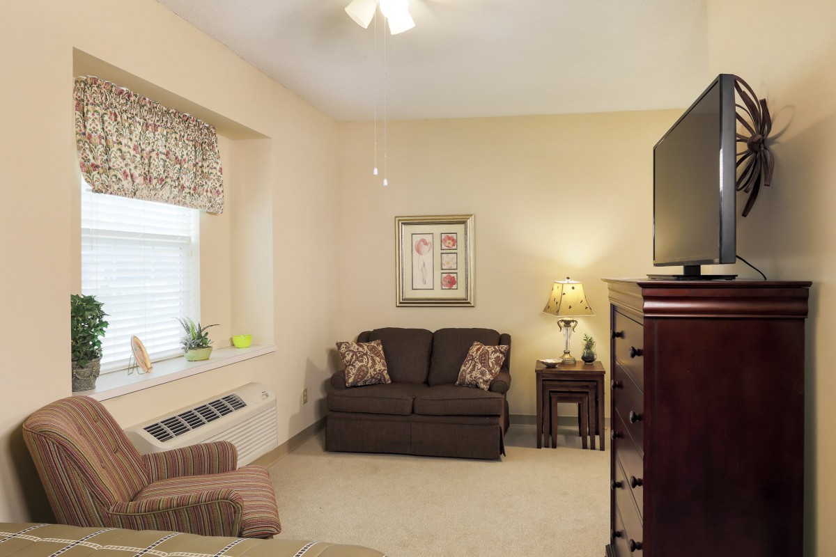 A cozy living room with a sofa, TV, and elegant decor.