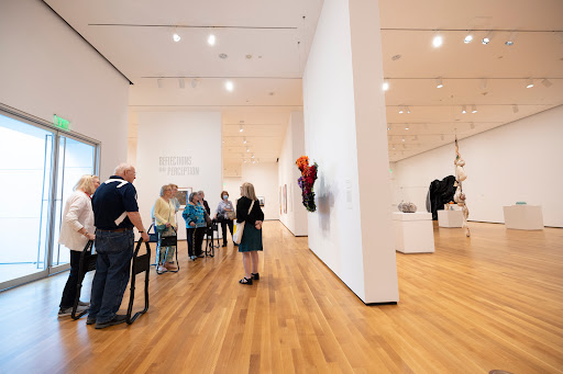 Visitors exploring an art gallery filled with modern artwork.