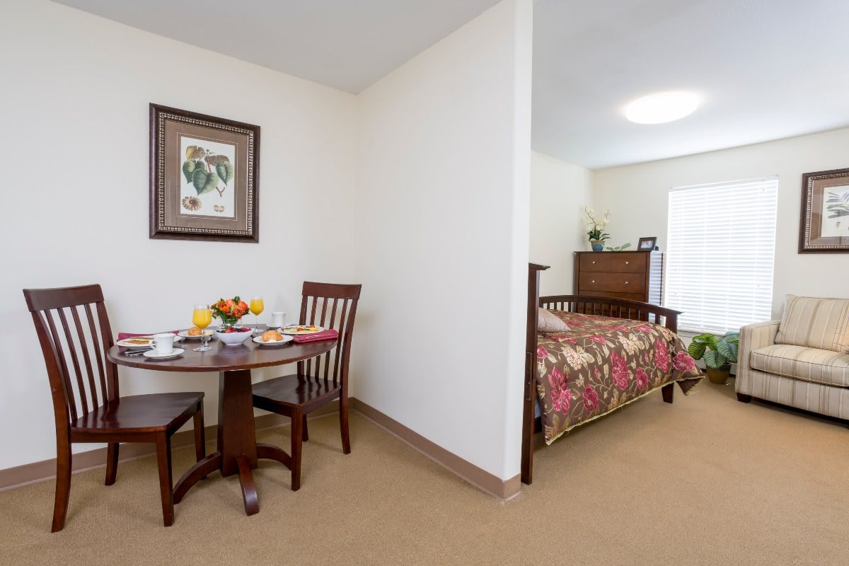 A cozy living space featuring a small dining area and adjoining bedroom.