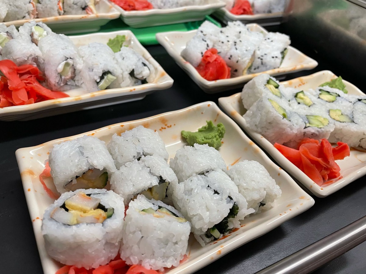 Plates of California rolls garnished with wasabi and pickled ginger.