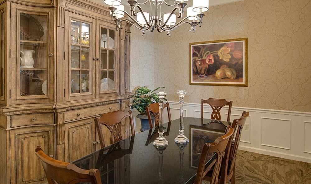 A classic dining room with wooden furniture and a chandelier.