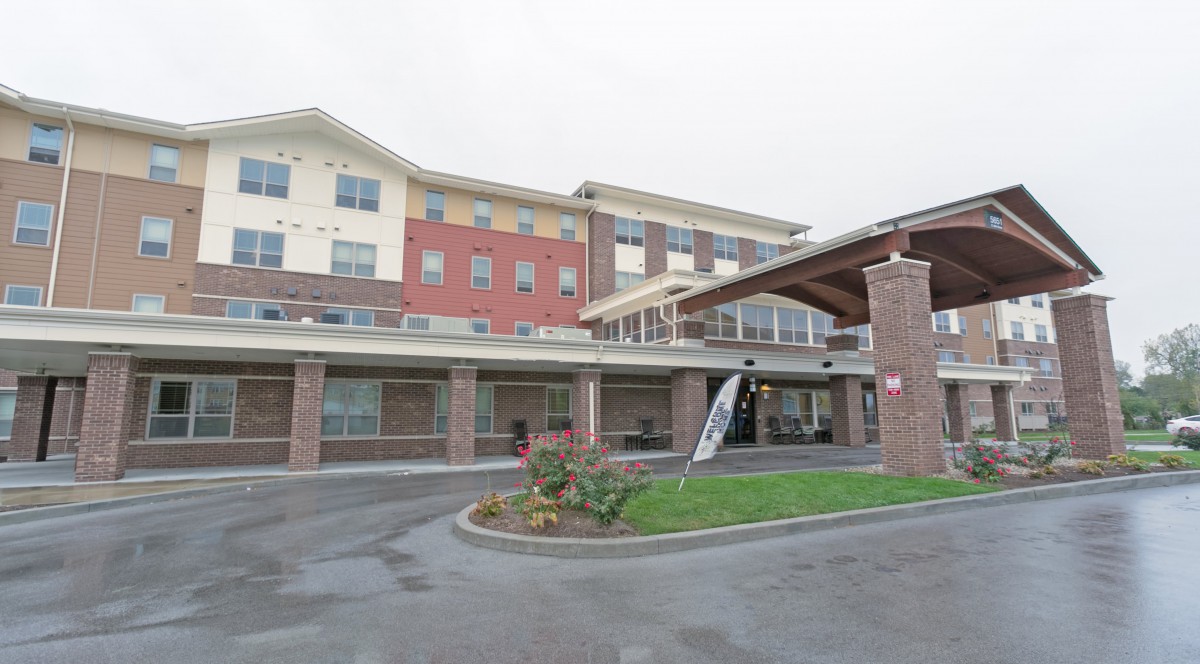 Exterior view of a modern multi-story residential building with landscaped entrance.