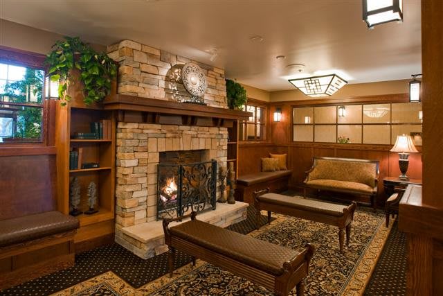 A cozy living room with a rustic fireplace and warm wooden accents.