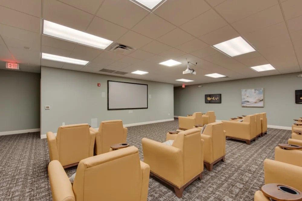 A cozy home theater setup with comfortable seating and a large screen for viewing.