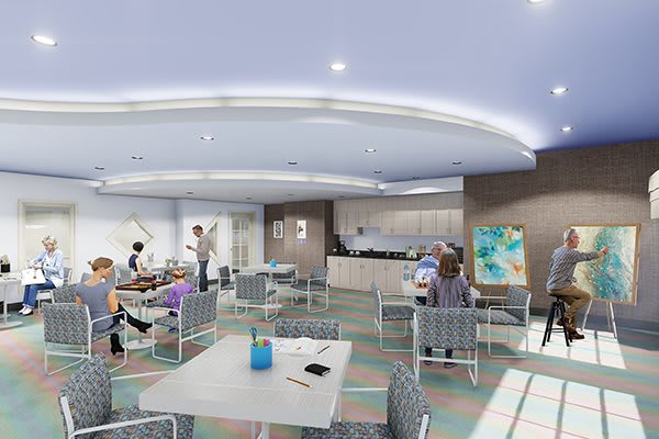 A modern waiting room with seating and a reception desk, featuring a few people gathered in the space.
