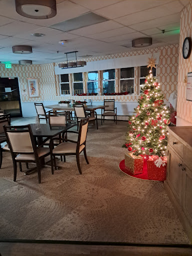 A cozy dining area decorated for the holidays, featuring a beautifully lit Christmas tree.
