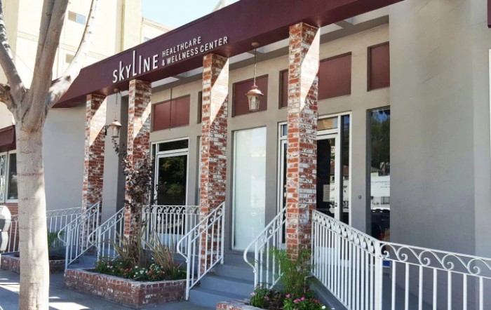A view of a commercial business entrance with a brick facade and awning.