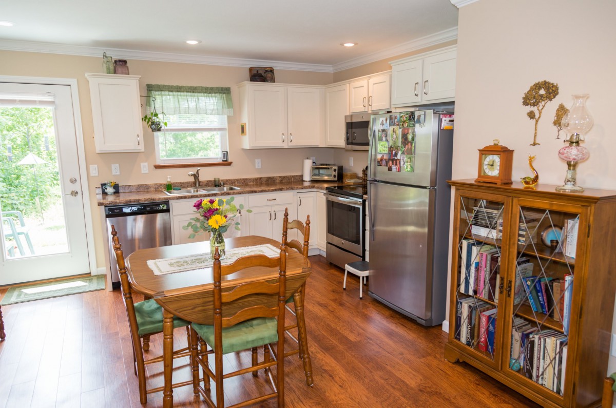 A cozy kitchen with a dining table and stainless steel appliances.