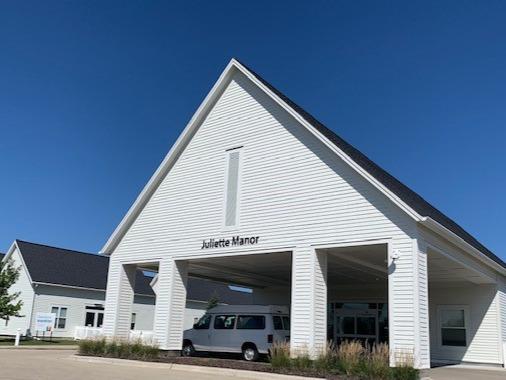 A contemporary white building with a peaked roof and clear blue sky.