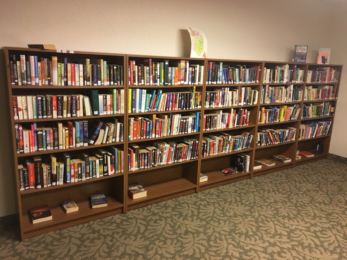 A well-organized library section with rows of books on wooden shelves.