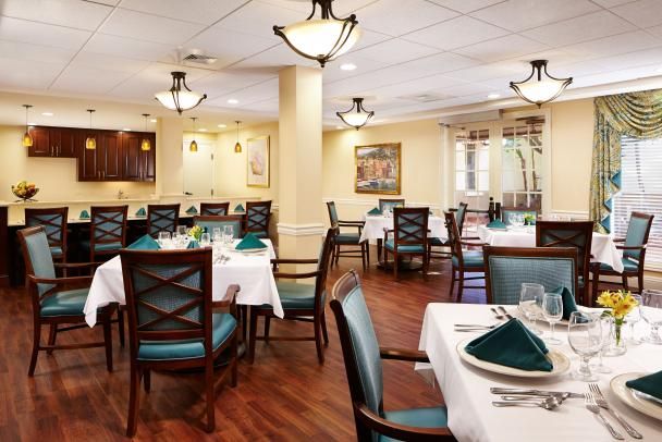 An elegant dining area with neatly set tables and comfortable seating, featuring soft lighting and warm decor.