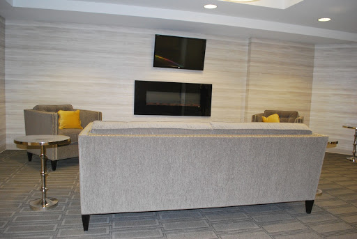 A modern lounge area featuring comfortable sofas, a wall-mounted television, and an elegant fireplace.