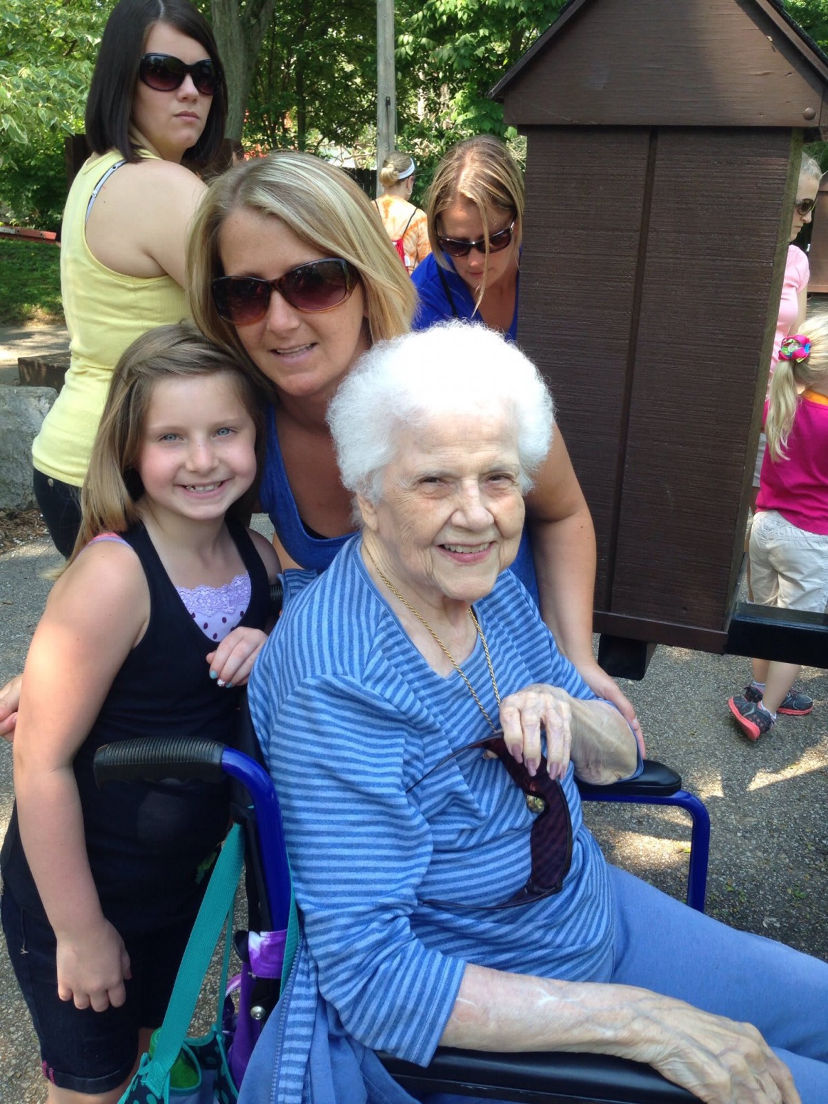 A family photo with three generations enjoying time outdoors.