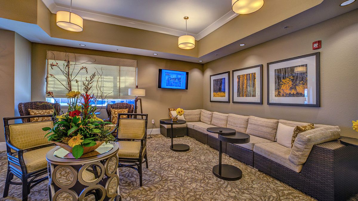 A modern lounge area featuring comfortable seating, tasteful artwork, and ambient lighting.