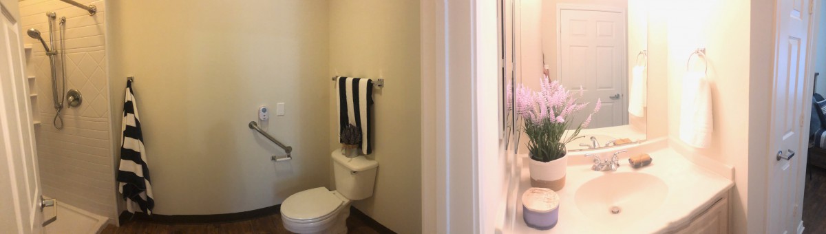 A small bathroom with a toilet, towel rack, and sink visible.