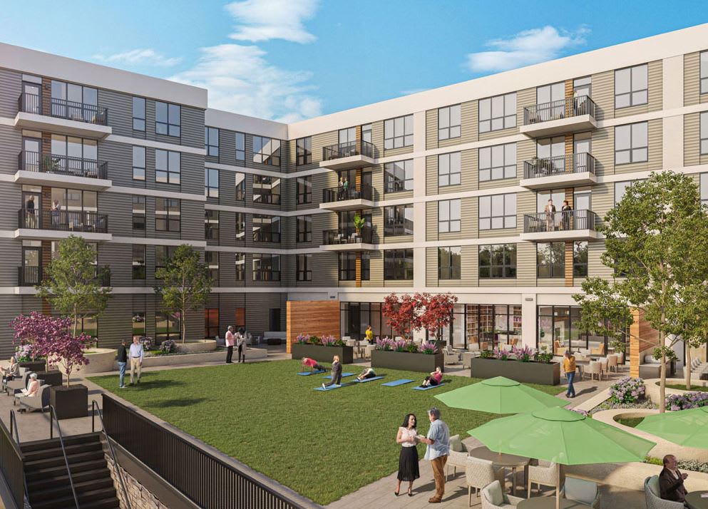 A modern apartment building with a spacious courtyard featuring green spaces and recreational areas.