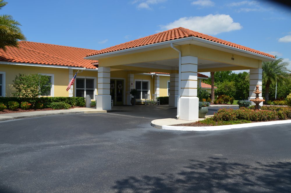 A building with a covered entrance and landscaped surroundings.