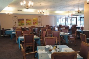A well-lit restaurant dining area with neatly arranged tables and chairs.
