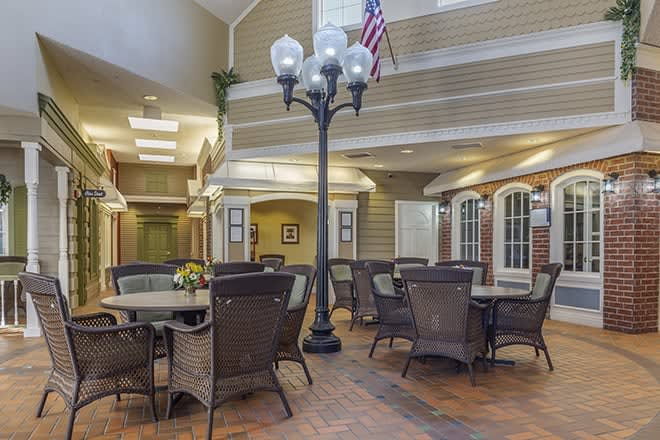 A cozy indoor seating area with tables, chairs, and a decorative lamp post.