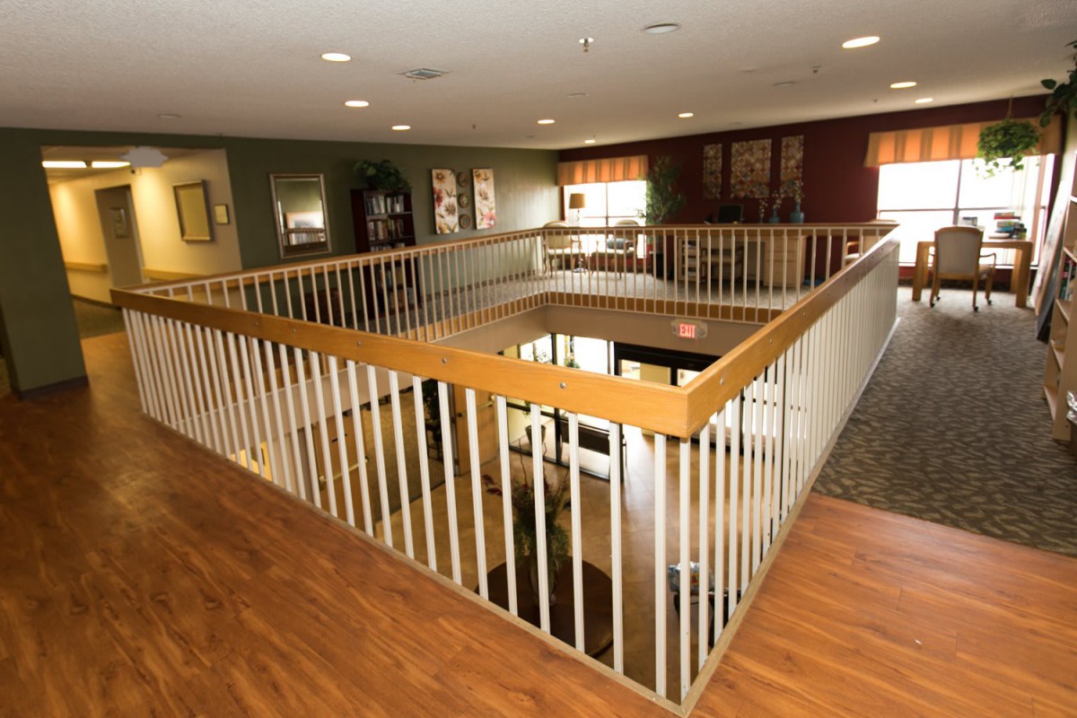 A spacious interior area with wooden railings and flooring, overlooking a lower level.