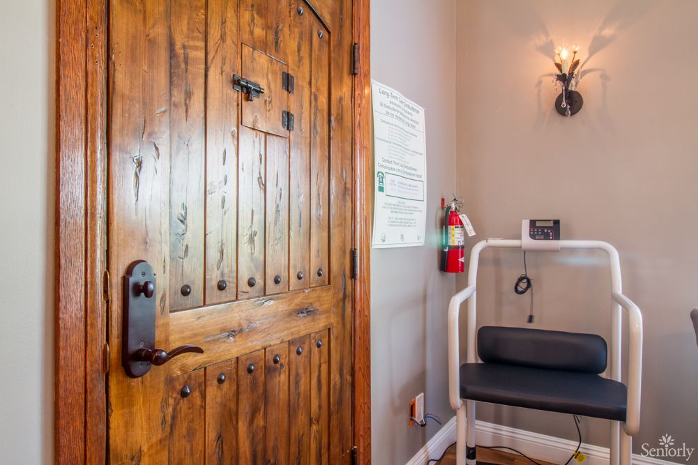 A cozy interior corner featuring a rustic wooden door and a small seating area with a fire extinguisher nearby.