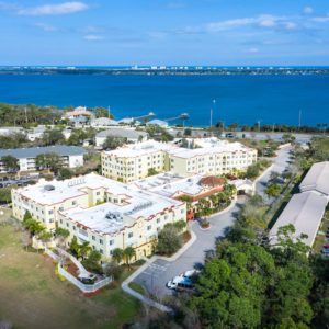 Aerial view of an apartment complex situated near a waterfront.