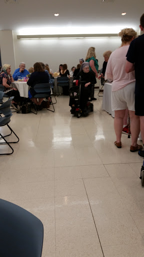 A gathering of people seated at tables in a spacious indoor area.