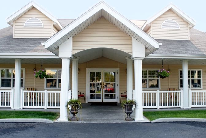 A residential building entrance with a porch and columns.