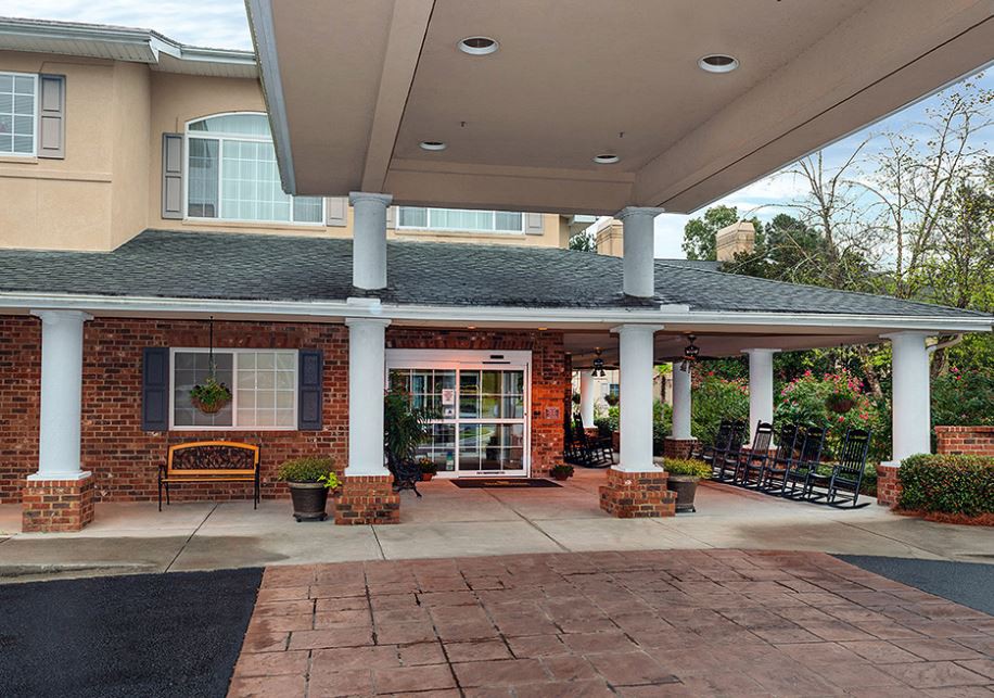 The image shows the entrance to a building with a covered porch and columns.
