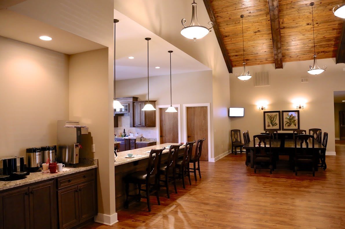 A modern kitchen and dining area with pendant lighting and wooden flooring.