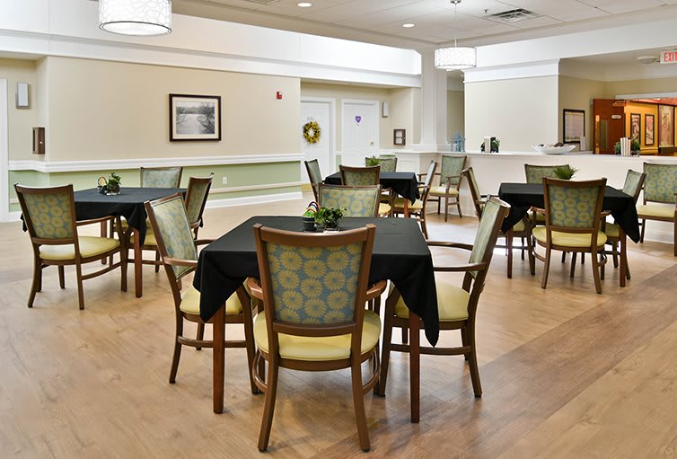 A well-lit dining area with neatly arranged tables and chairs, featuring modern decor.