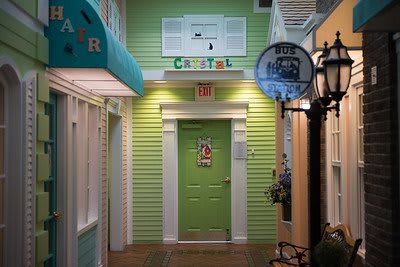 A colorful indoor hallway featuring a green door with decorative elements.