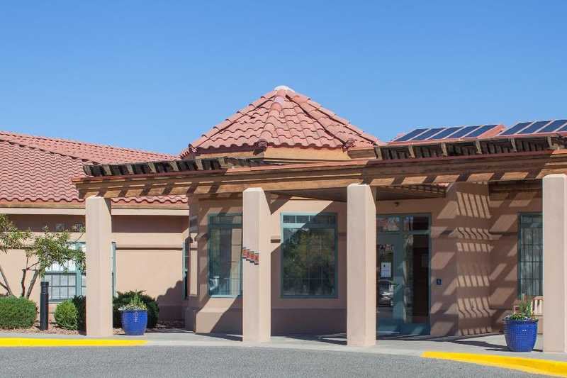 An entrance to a building with a tiled roof and large windows.