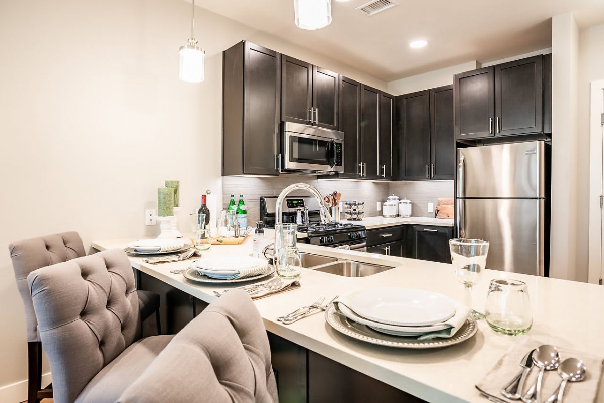 A modern kitchen and dining area with sleek, stainless steel appliances and contemporary furnishings.